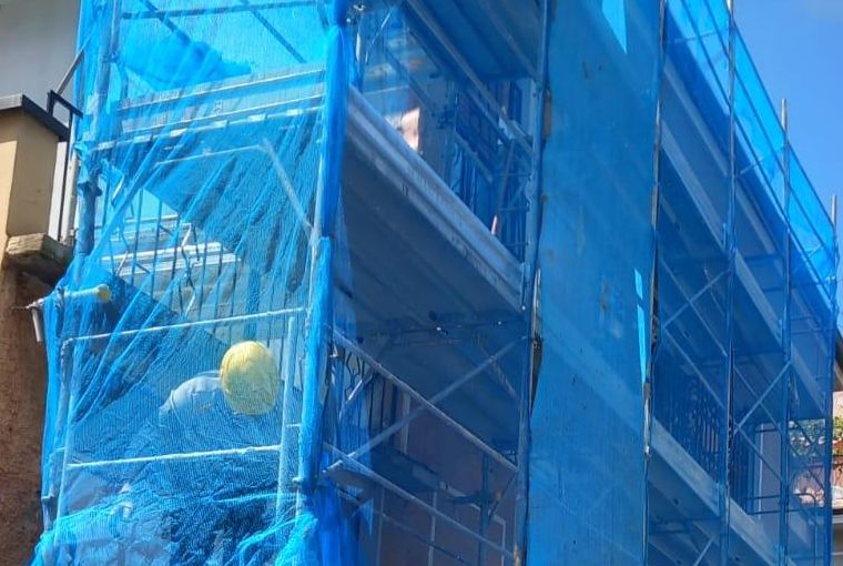 Ponteggio con rete blu montato su una facciata